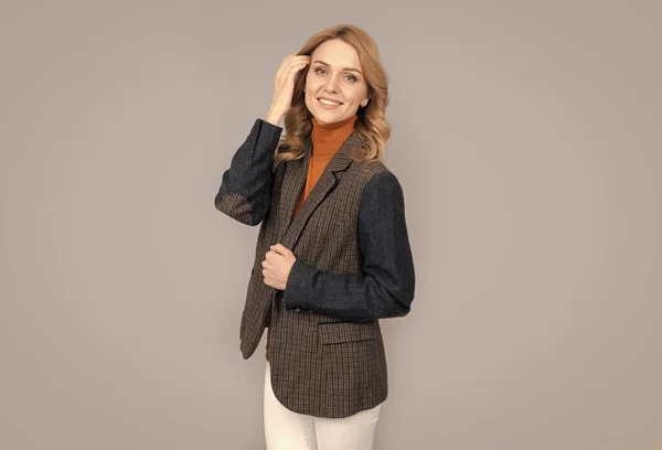 Mujer rubia alegre en chaqueta británica casual de negocios sobre fondo gris, belleza — Foto de Stock