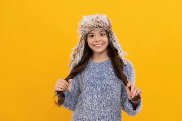 Ευτυχισμένο παιδί μακριά μαλλιά στο καπέλο σε κίτρινο φόντο, το χειμώνα — Φωτογραφία Αρχείου