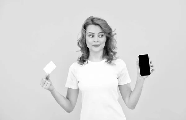 Femme gaie montrant carte de crédit ou de débit et smartphone pour faire des achats en ligne, cyber lundi. — Photo