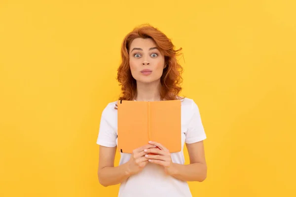 Meglepetés lány hold copybook sárga háttér, tudás — Stock Fotó
