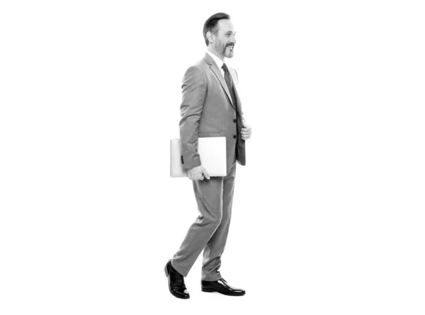 Happy grizzled businessman in suit full length walking with computer isolated on white, business — Stock Photo, Image