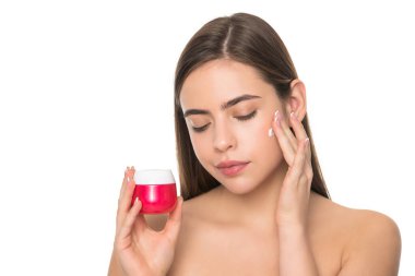 Beyaz arka planda izole edilmiş cilt kremi süren genç bir kız, günlük alışkanlık.