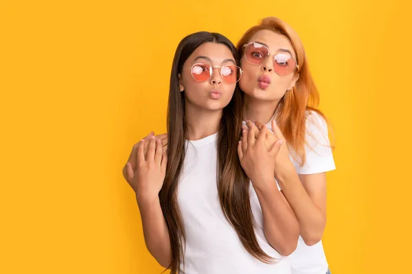 Beso de golpe. madre e hija en gafas de sol. belleza y moda. modelo de moda femenina. —  Fotos de Stock