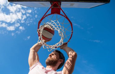 Smaç basıldı. Yaz etkinliği. Basketbol topuyla sahada zıplayan adam..