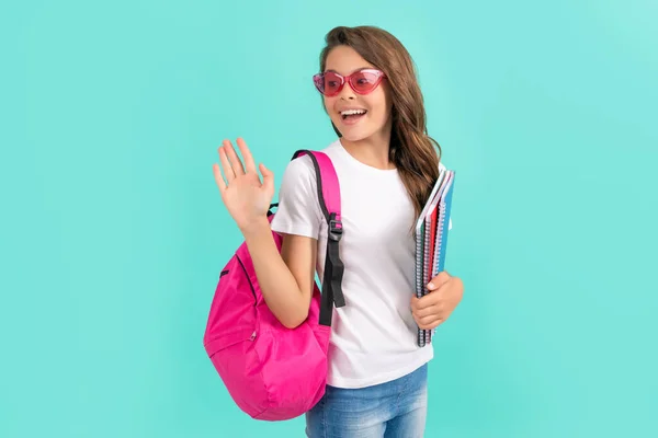 Feliz adolescente chica con mochila y copybook listo para estudiar en la escuela saludando, escuela —  Fotos de Stock