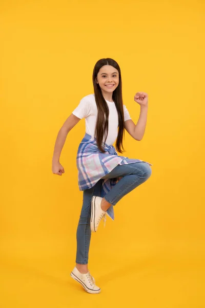 Hipster gelukkig kind in casual kleding volledige lengte run op gele achtergrond — Stockfoto