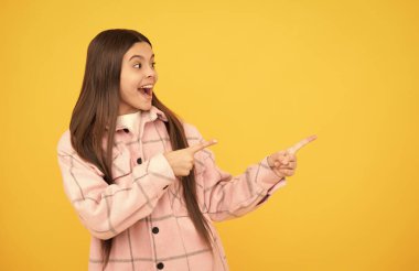 Şaşırmış çocuk pembe kareli gömlek giyer ürün sunar, kopya alanı, duyuru