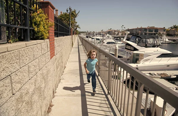 Bycie aktywnym. Aktywny dzieciak biegnie promenadą. Energiczny chłopak lubi biegać. Aktywność letnia. Dobrze się bawię — Zdjęcie stockowe