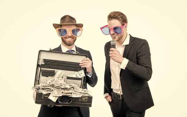 Счастливый emcee интервью богатый спонсор с деньгами чемодан изолирован на белом, спонсируя — стоковое фото