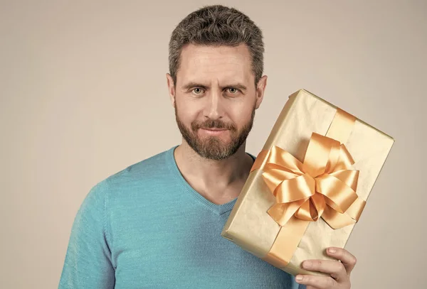 Hombre maduro guapo hombre de negocios con barba sosteniendo regalo o caja de regalo, aniversario —  Fotos de Stock