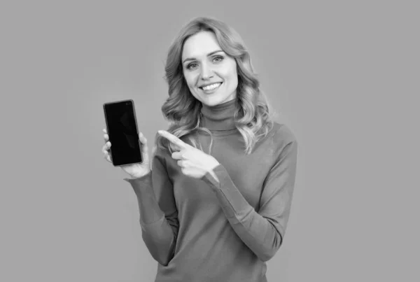 Bonne fille pointant du doigt le téléphone portable. index de pointage pour la publicité — Photo