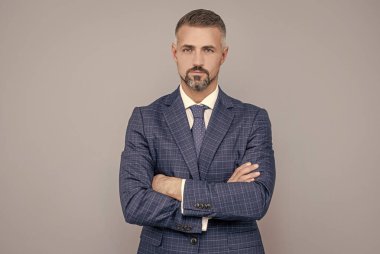 Takım elbiseli kendine güvenen işadamı ellerini çapraz yaptı.