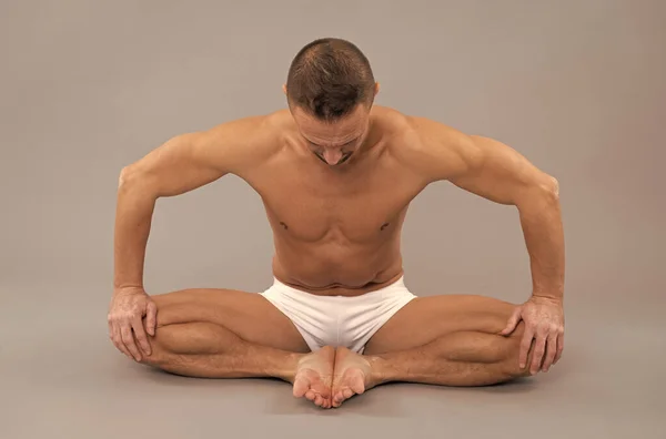 Yogi man do bound angle pose. Practicing thighs stretch. Yoga stretch. Butterfly Asana
