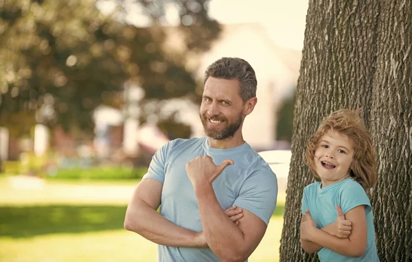 C'est cool. Un homme heureux pointe du doigt un garçon qui montre ses pouces. Cool famille. Enfance et parentalité. Relation parent-enfant — Photo