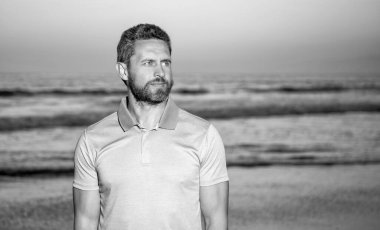 Olgun bir adam gözlerini denize çeviriyor yaz kumsalında, kopya alanı, moda