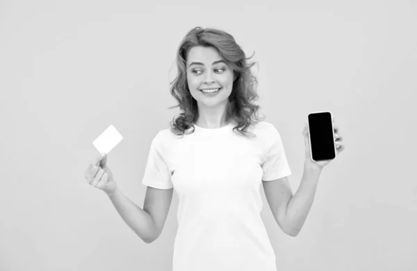 Mujer feliz mostrando tarjeta de crédito o débito y teléfono inteligente para hacer compras en línea, pago en línea. —  Fotos de Stock