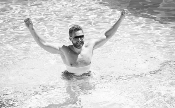 Szczęśliwy brodaty mężczyzna w okularach przeciwsłonecznych bawić się w basenie woda w letnie wakacje, letnie wakacje. — Zdjęcie stockowe