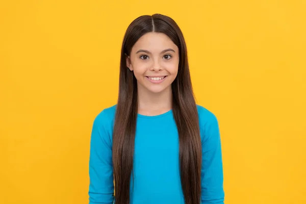 Veselá teen dívka s dlouhými vlasy na žlutém pozadí, móda — Stock fotografie