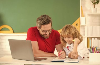 Öğretmen ve öğrenci sınıfta dizüstü bilgisayarla, eğitimle