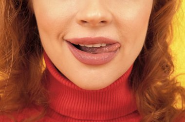 Kız alt yüzü yalayarak dudaklarını diliyle yalıyor.