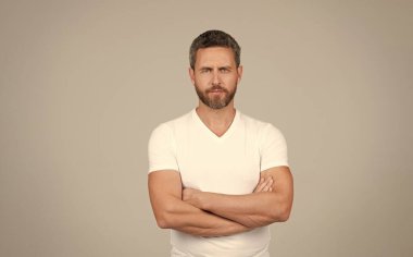 Kendine güveni olan adam. Kendine güveni tam, gri bir geçmişi var. Ciddi bir adam kollarını kavuşturur.