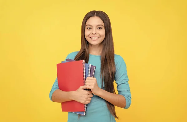Wesoły dziecko dziewczyna trzymać notatnik do pracy domowej, zadanie domowe — Zdjęcie stockowe