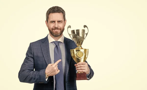 mature businessman in suit pointing finger on golden cup. business success.