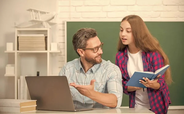 Curious teen girl and teacher man in high school with workbook and pc at blackboard, parenthood — Stock Photo, Image