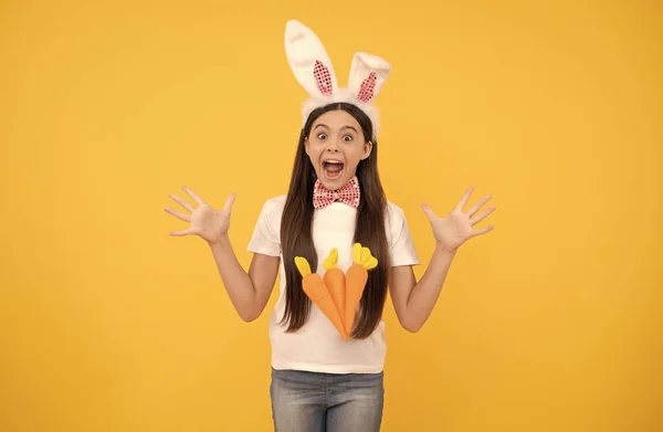 Olha para aqui. Um coelhinho alegre com cenoura. Feliz feriado de Páscoa. criança engraçada em orelhas de coelho. — Fotografia de Stock