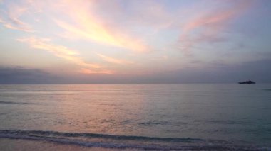 Gün batımında güzel bir sahil. Gökyüzü yatlı, gün batımlı.