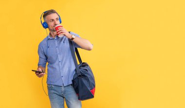 Adam kahve içerken kulaklıkla sohbet ediyor. kopyalama alanı. İş adamı