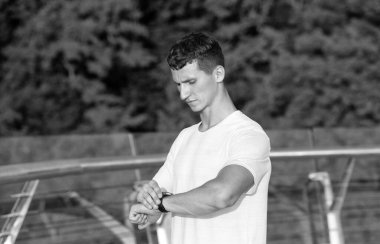 Atletik adam açık hava antrenmanı, spor zamanlaması sırasında bilek nöbetini kontrol ediyor.