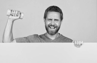 Ağırlık çalışması. Sporcu, halterleri sarı arkaplanda tut.