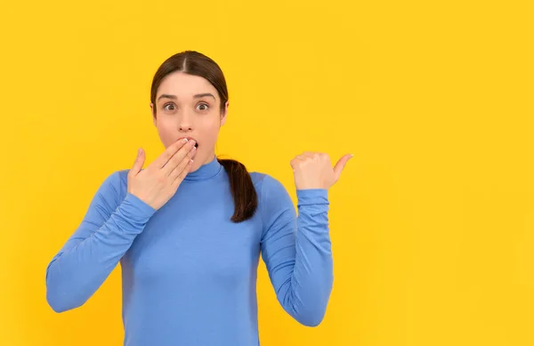 Chockad kvinna porträtt peka fingrar på kopia utrymme gul bakgrund, reklam — Stockfoto