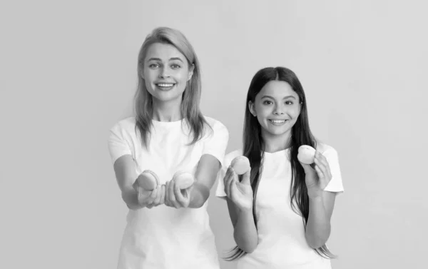 Família feliz de mulher e adolescente menina segurar biscoitos de macaron francês, macaroon francês — Fotografia de Stock