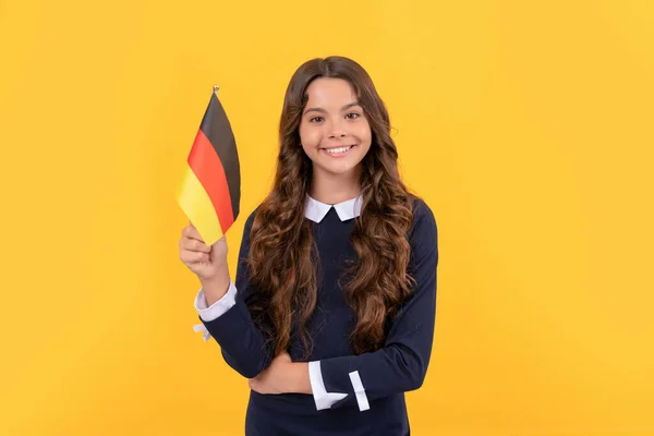 Šťastný kluk drží německou vlajku žluté pozadí, studuje v zahraničí — Stock fotografie