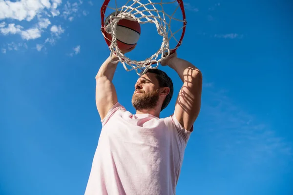 Clavado en la cesta. slam dunk en movimiento. actividad soleada de verano. hombre con pelota de baloncesto — Foto de Stock