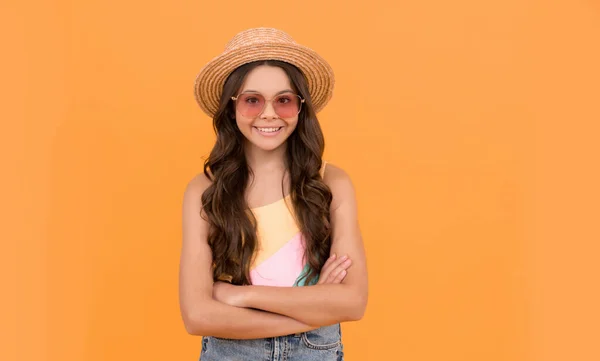 小美人儿小孩戴着草帽和眼镜。一个有着橙色背景的快乐小女孩. — 图库照片