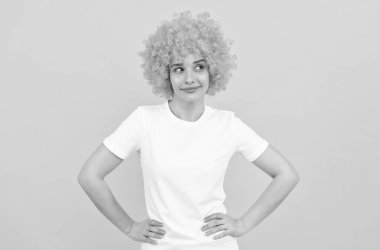 Flört ediyormuş gibi. Neşeli bayan peruk takıyor. Kadının turuncu saçları var. Palyaço olmak. 1 Nisan 'da.