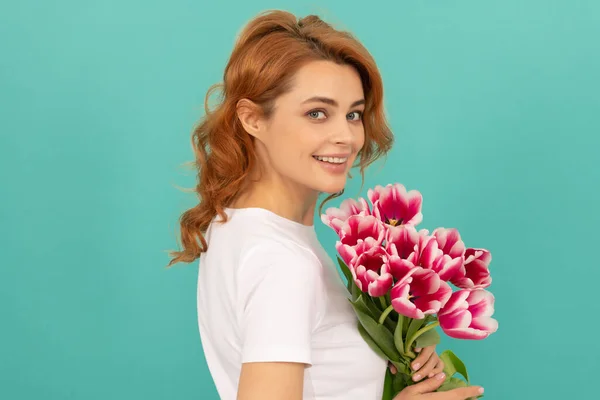 Mavi arka planda lale çiçeği buketi olan mutlu kız. Kadınlar Günü — Stok fotoğraf