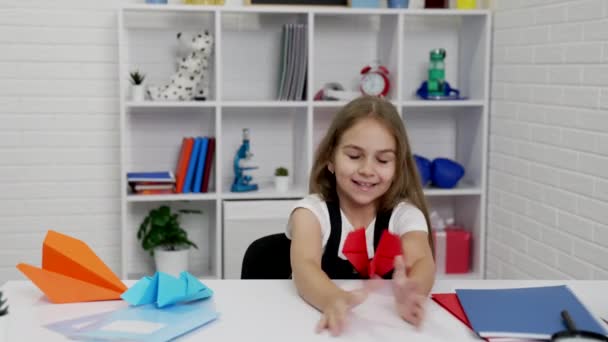 Щаслива дитина весело грає з паперовим літаком на уроці школи в класі, дитинство — стокове відео
