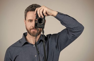 İhtiyacın olduğunda kamera teçhizatı. Sakallı adam kamerayla fotoğraf çek.