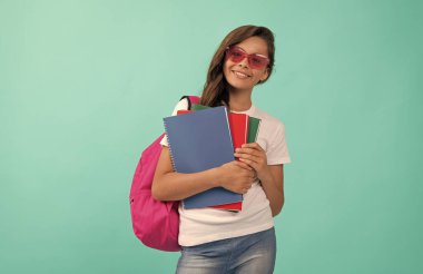Sırt çantası ve güneş gözlüklü mutlu çocuk okula, okula gitmeye hazır.