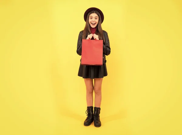 Šťastná teen dívka v klobouku a kožené oblečení držet nákupní tašku, nákup — Stock fotografie