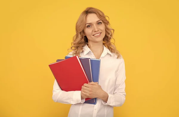Beyaz tişörtlü mutlu sarışın iş kadını elinde not defteri ya da not defteri, öğretmen. — Stok fotoğraf