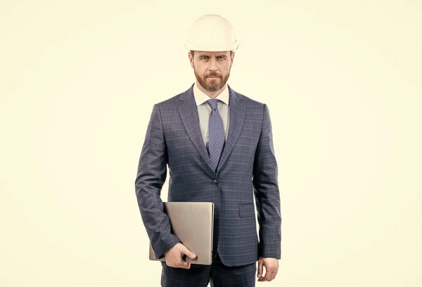 Confident businessman man in suit and safety helmet hold laptop isolated on white, business — Stock Photo, Image