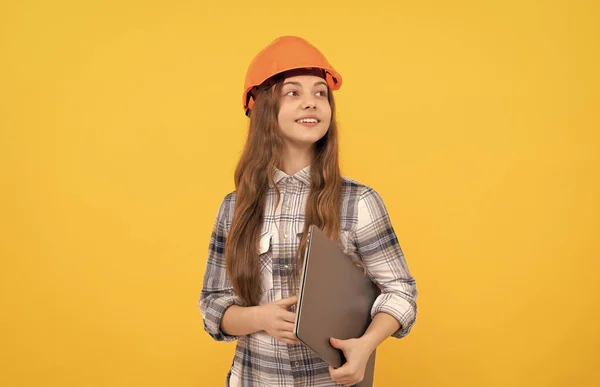 Feliz adolescente menina no capacete e xadrez camisa segurando computador, carreira futura — Fotografia de Stock