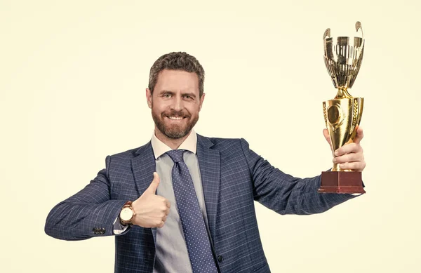 Happy boss hold golden cup giving thumbs up hand gesture isolated on white, best