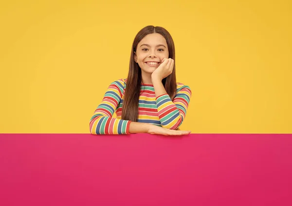 Menina adolescente feliz por trás folha de papel rosa com lugar vazio para espaço de cópia, anúncio — Fotografia de Stock