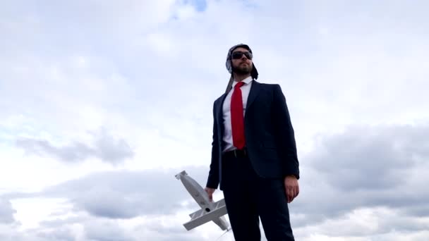 Homme d'affaires en costume et chapeau de pilote avec lunettes tenir l'avion, voyage d'affaires — Video